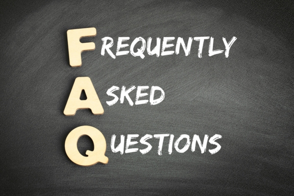 Frequently asked questions FAQ spelled using wooden letters and the sentence written using chalk