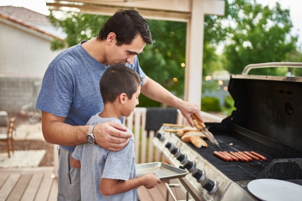 father and son enjoying summer backyard barbecue