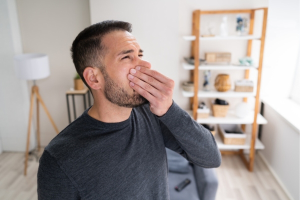 man covering his nose due to bad smell coming out of AC