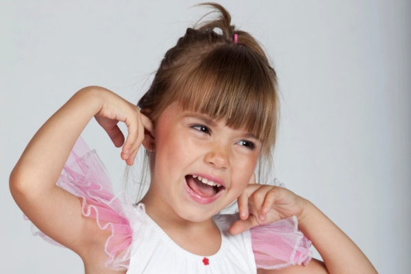 young girl covering ears depicting Air Conditioner making Loud Noise When Starting