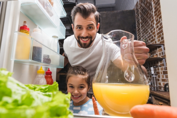 father and daughter getting food and juice from the fridge depicting power supply from a standby generator