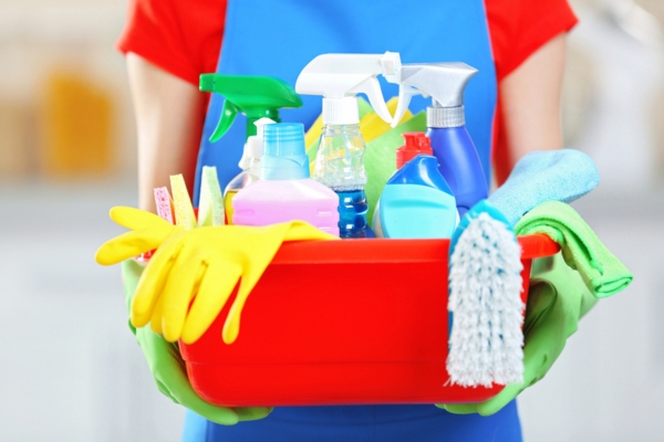 cropped view of a woman holding cleaning materials depicting cleanliness around furnace