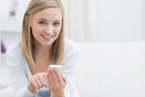 woman dialing on her phone calling a professional HVAC contractor for furnace repair