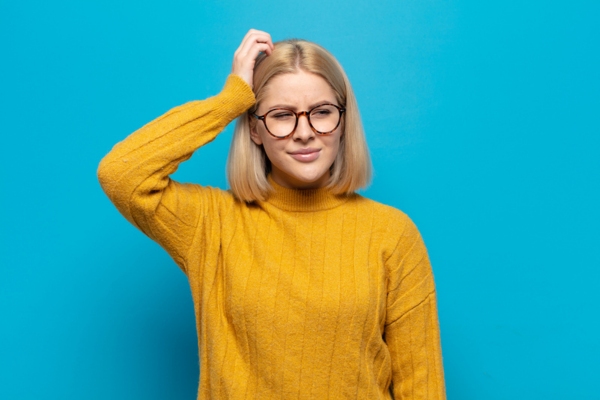 woman scratching her head due to furnace reset button not working