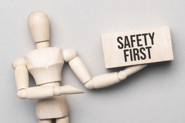 wooden figure holding safety first sign depicting emergency response and safety measures and fuel delivery