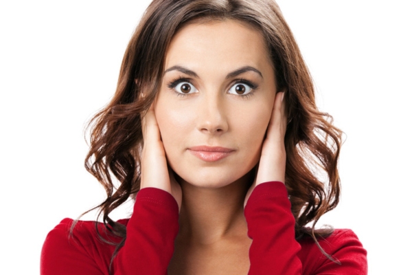 woman covering her ears depicting loud sounds coming from the furnace