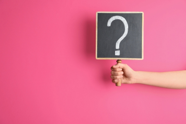 Woman holding blackboard with question mark depicting FAQs about Air Conditioning Safety