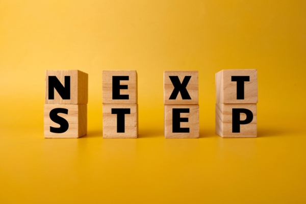 Wooden cube with the word NEXT STEP on yellow background depicting connecting alexa to smart oil gauge