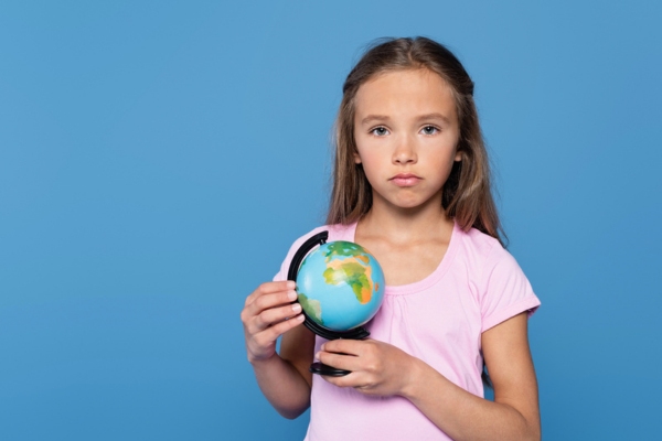 sad kid while holding a globe depicting outdated air conditioner & environmental toll