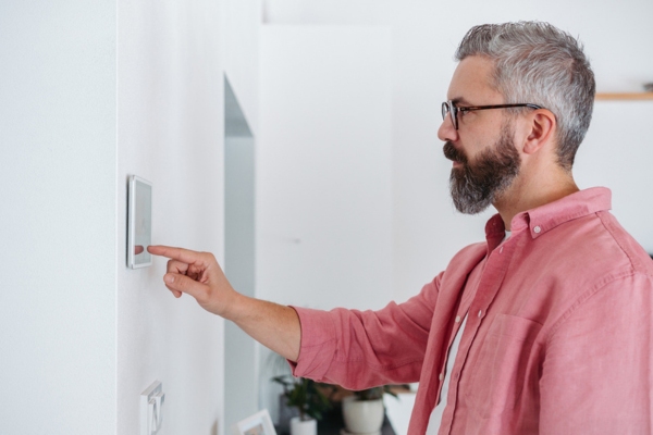 man adjusting home thermostat