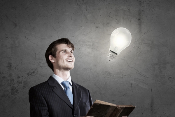 man holding a book while looking at idea lightbulb depicting understanding double-wall heating oil tank