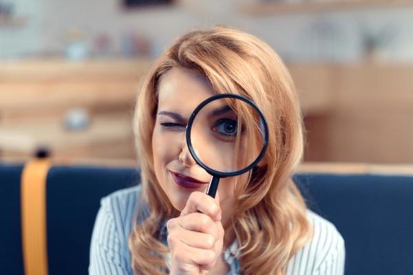 woman holding a magnifying glass on her eye depicting A Closer Look at AFUE and AFUE2