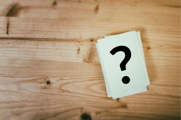 Question mark on a stack of paper on top of a wooden table depicting FAQs about Cracked Heat Exchanger