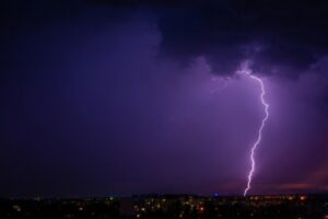 Lightning strikes during storm over city night light