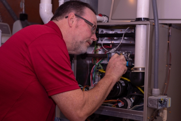 HVAC technician performing furnace inspection