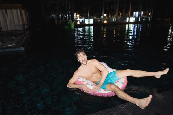 excited man swimming at night in a heated pool
