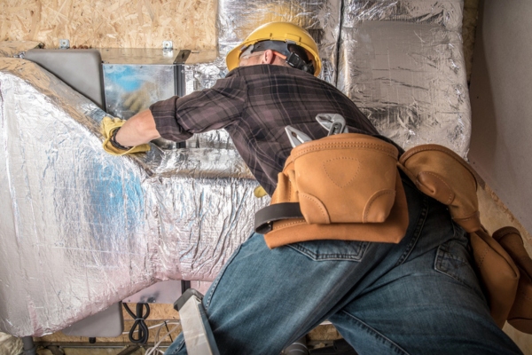 HVAC technician inspecting ductwork
