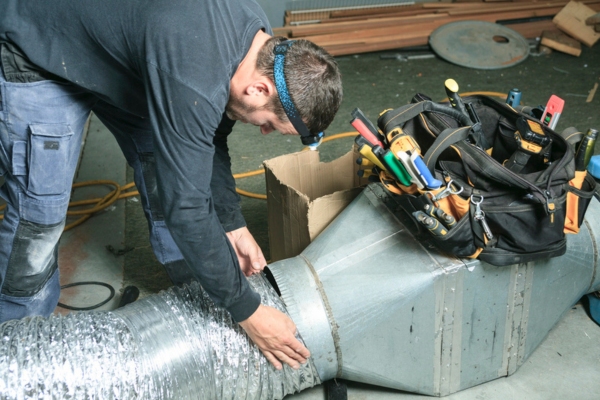 HVAC technician tending to a home's ductwork