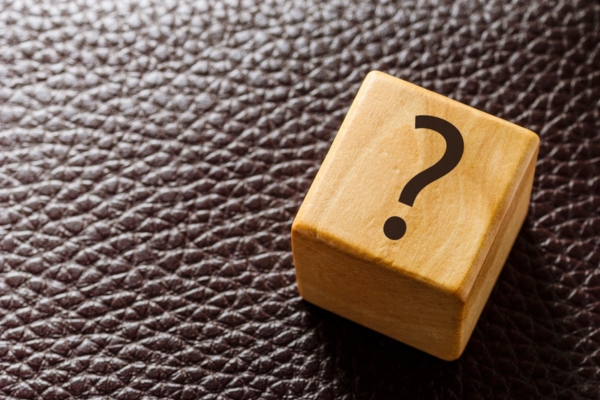 question mark on a wooden dice depicting HVAC Maintenance Agreements FAQS