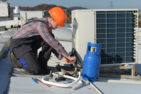 HVAC technician refilling refrigerant on an air conditioner