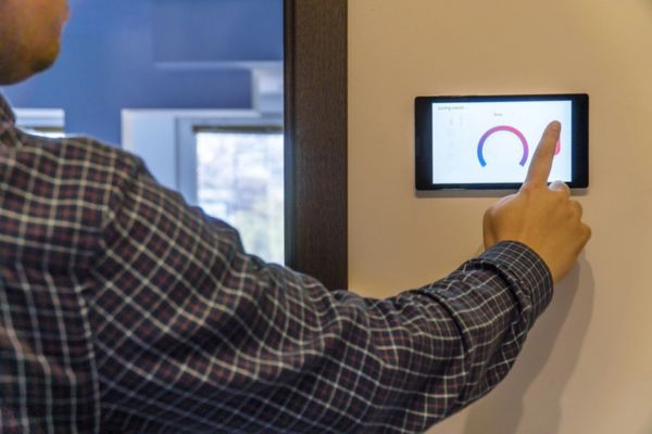 homeowner adjusting smart climate control device at home