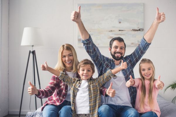 family of four doing a thumbs up on both hands depicting Why Is Heating Oil a Dependable Home Heating Choice